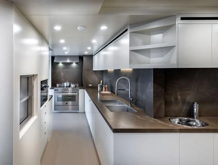 a kitchen with white cabinets aboard ALAIA Yacht for Sale