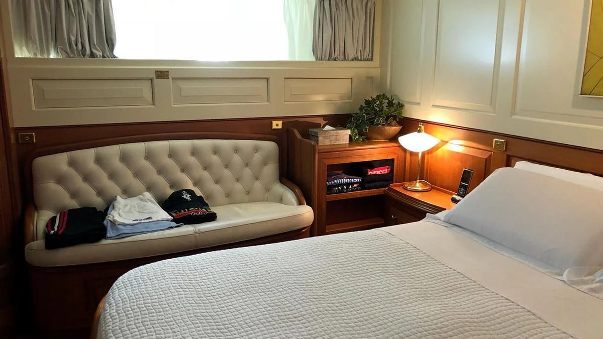 a bed with a white couch and a white pillow aboard LADY MAY OF GLANDORE Yacht for Sale