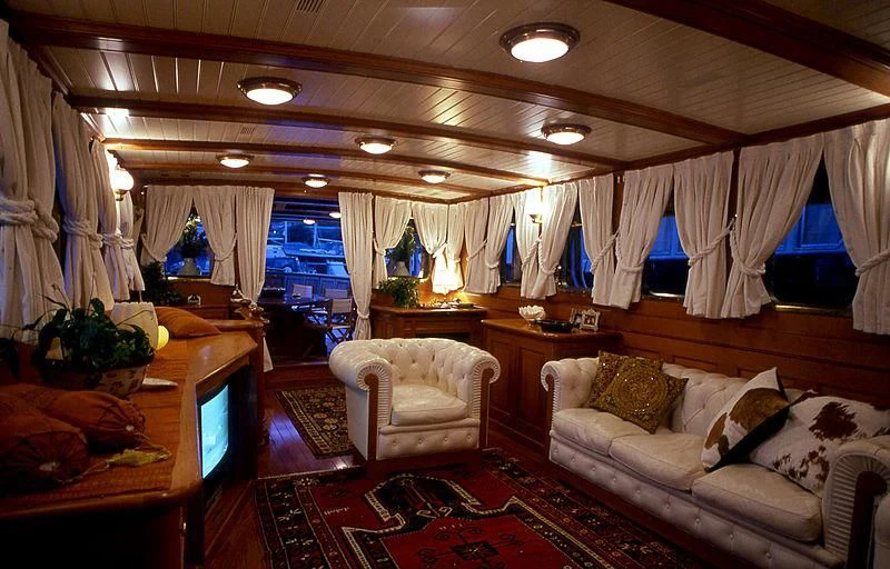 a living room with a red rug aboard LADY MAY OF GLANDORE Yacht for Sale
