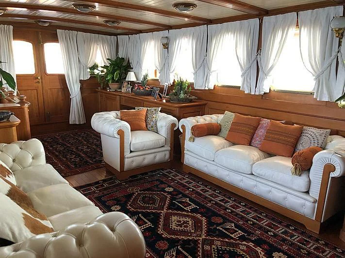 a living room with a couch and a table aboard LADY MAY OF GLANDORE Yacht for Sale