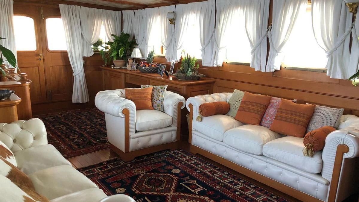 a living room with a couch and a table aboard LADY MAY OF GLANDORE Yacht for Sale