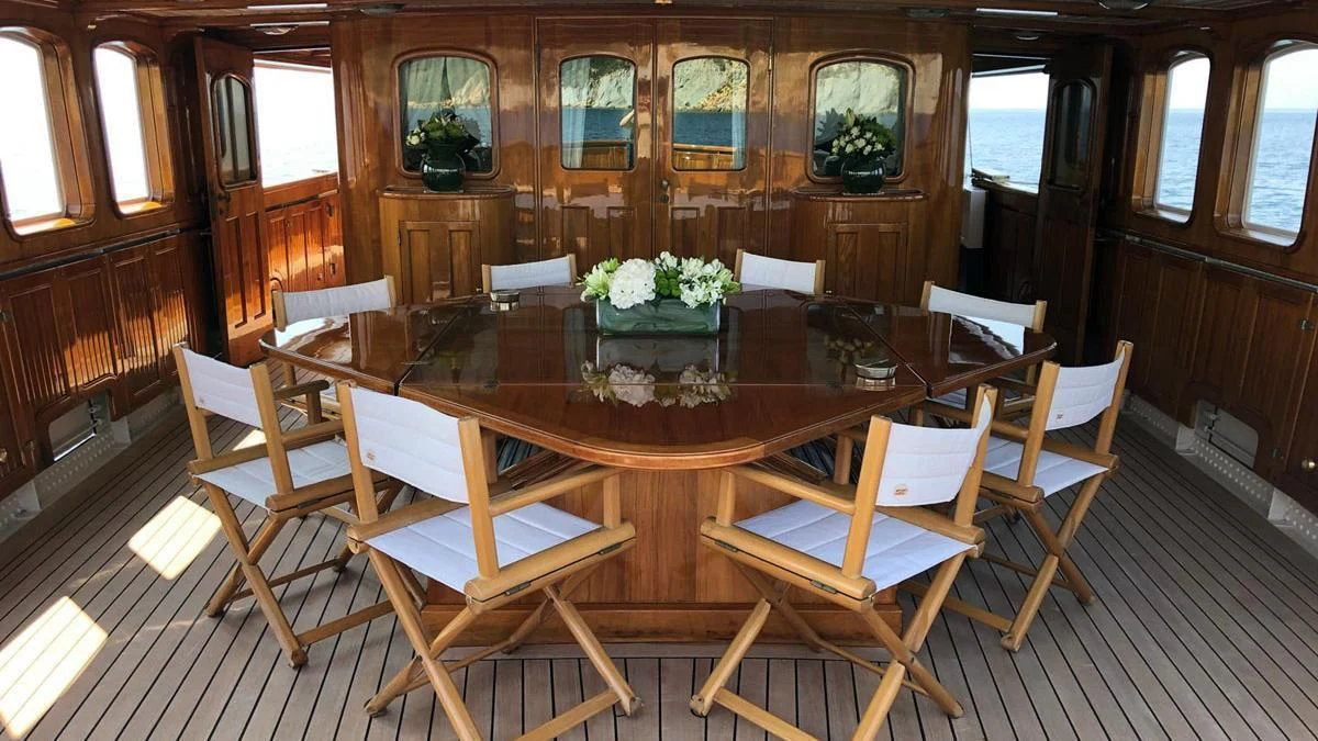 a room with a table and chairs aboard LADY MAY OF GLANDORE Yacht for Sale