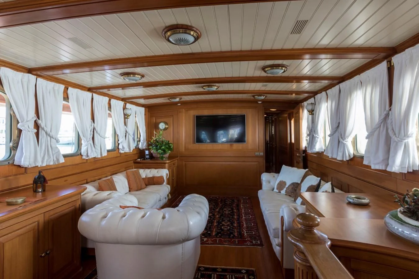 a room with a table chairs and a television aboard LADY MAY OF GLANDORE Yacht for Sale
