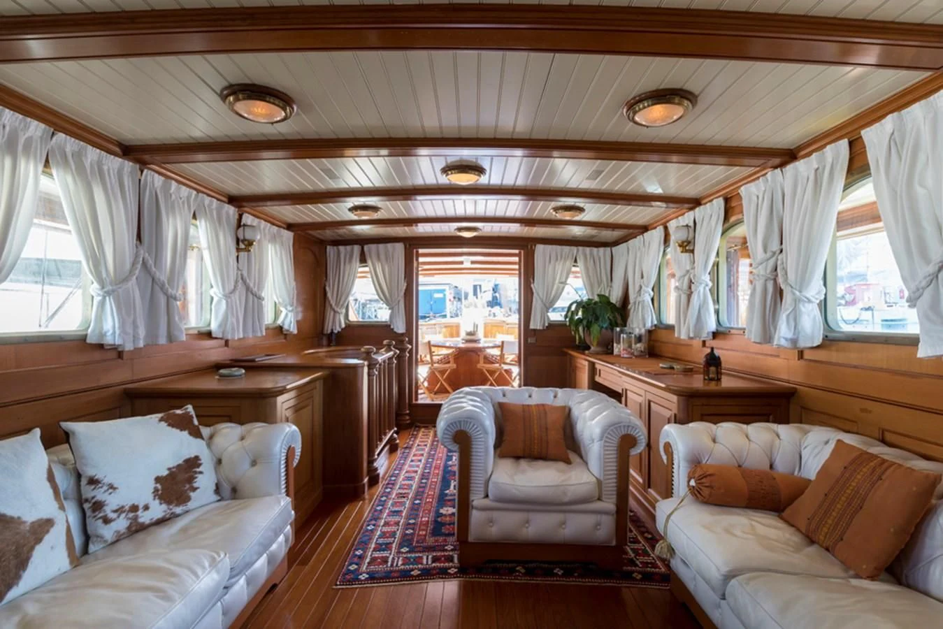a room with a couch and a table and chairs aboard LADY MAY OF GLANDORE Yacht for Sale