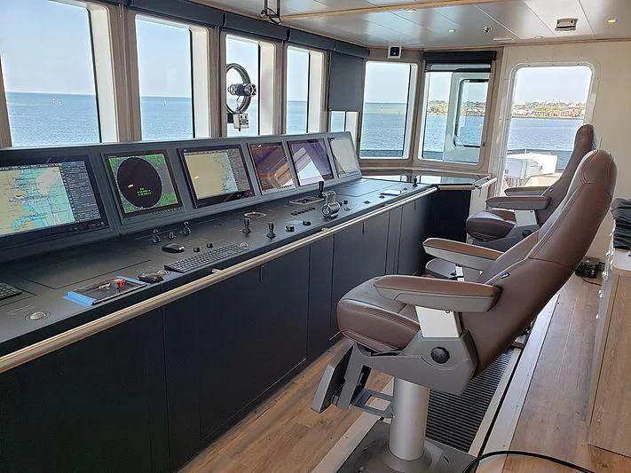 a room with a desk and chairs aboard VOYAGER Yacht for Sale