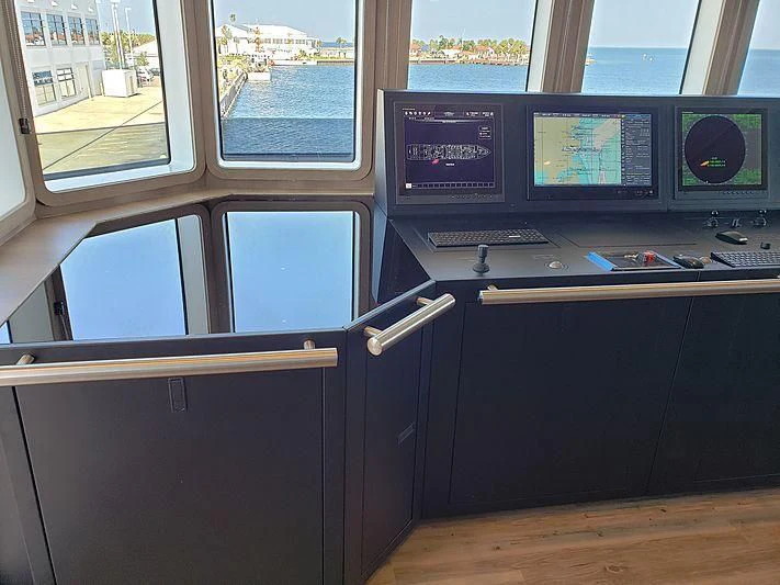 a computer desk with a monitor and keyboard aboard VOYAGER Yacht for Sale