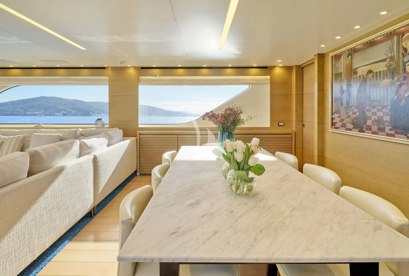 a dining table with a vase of flowers on it aboard FLOR Yacht for Charter