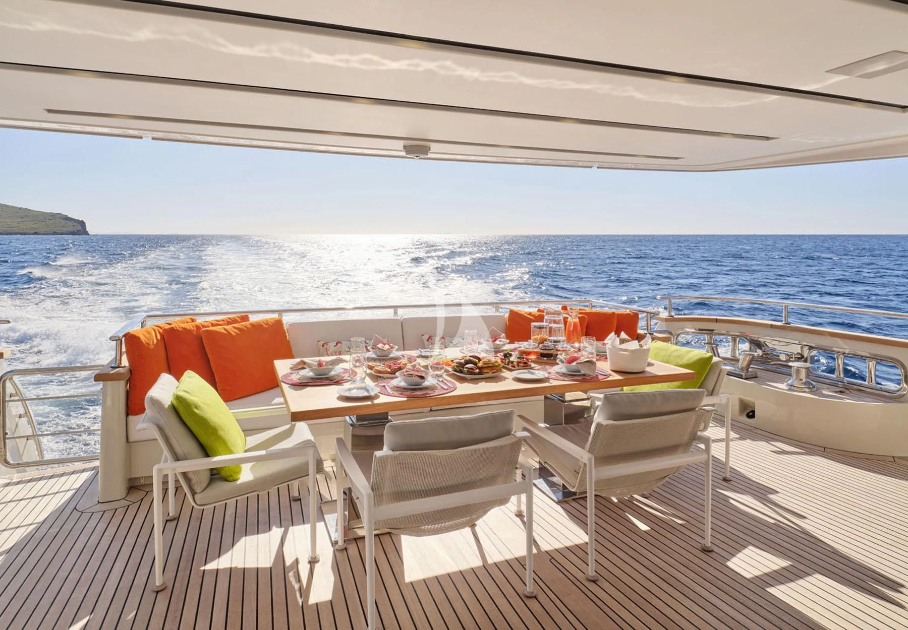 a table set on a deck overlooking the ocean aboard FLOR Yacht for Charter