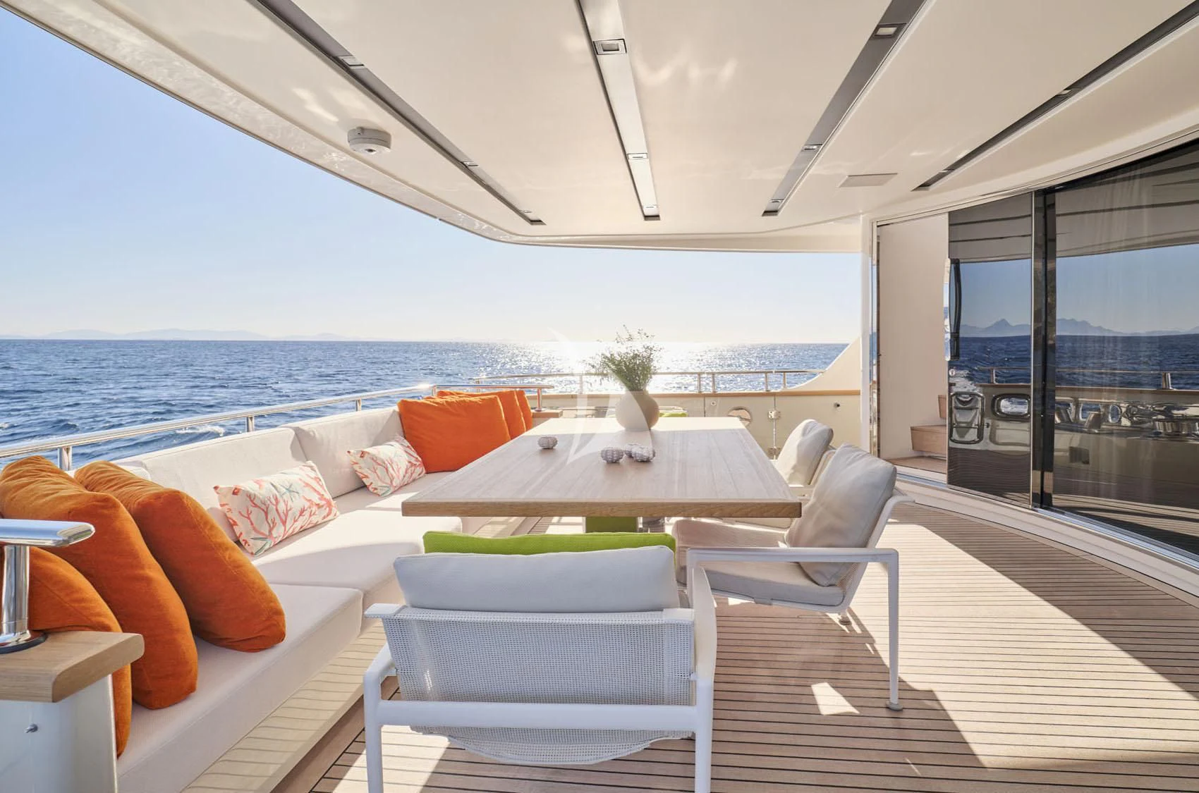 a room with a table chairs and a large window overlooking the ocean aboard FLOR Yacht for Charter