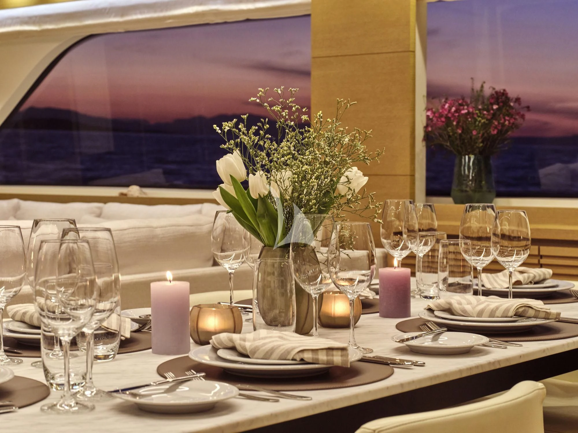 a table with plates and glasses aboard FLOR Yacht for Charter