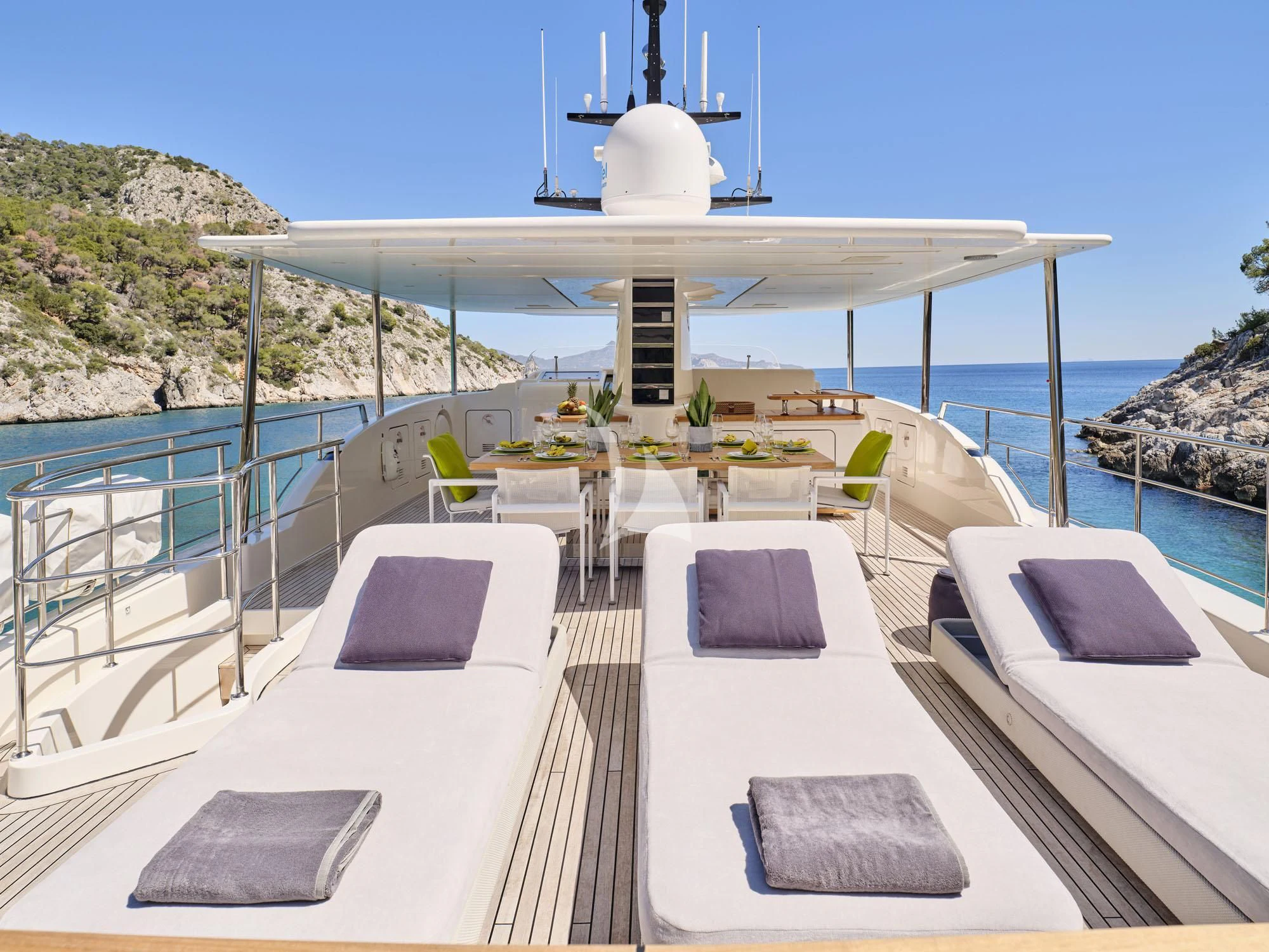 a deck with a pool and a deck with chairs and a building on it aboard FLOR Yacht for Charter
