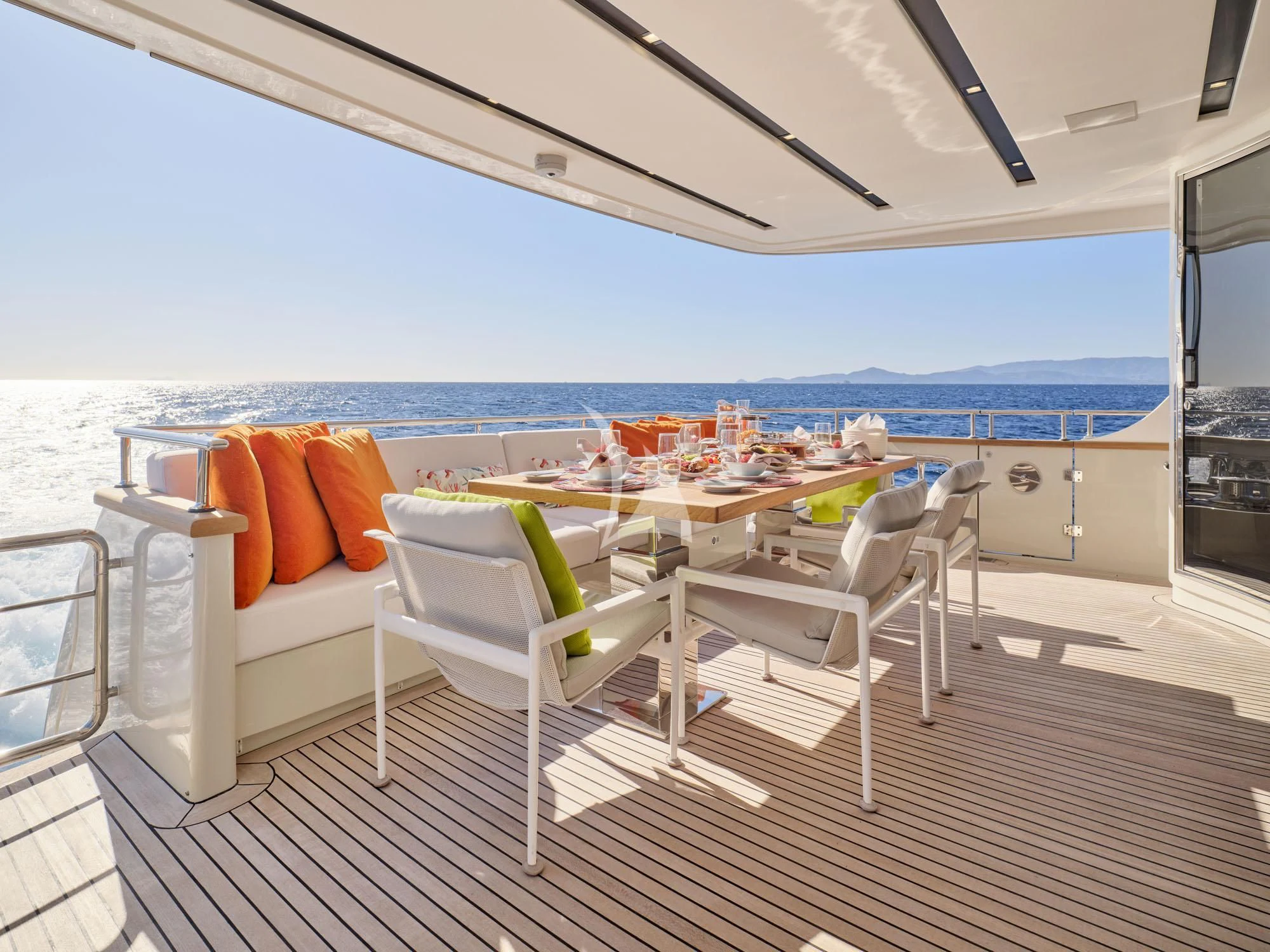 a deck with a table and chairs aboard FLOR Yacht for Charter