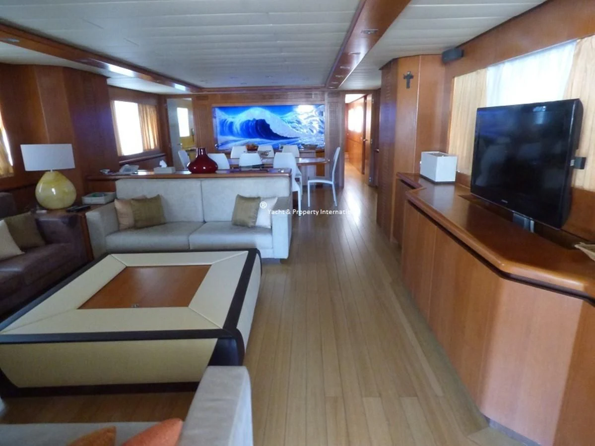 a living room with a tv and a table aboard BENETTI STYLE Yacht for Sale