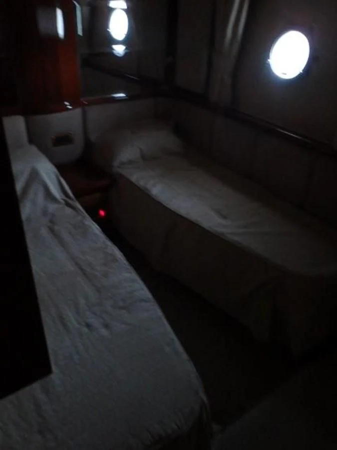 a room with a bed and a lamp aboard FREE SPIRIT Yacht for Sale