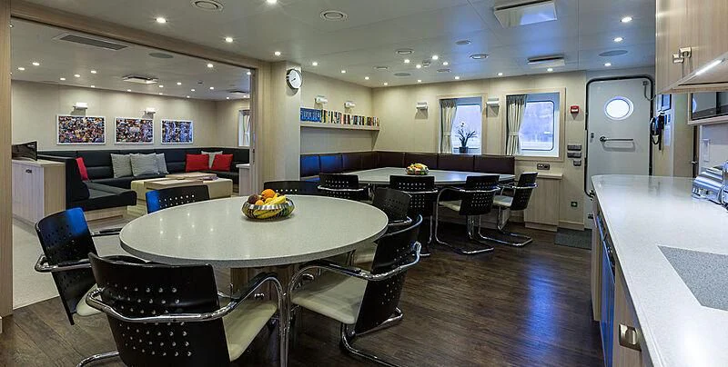 a large room with tables and chairs aboard GARCON Yacht for Sale