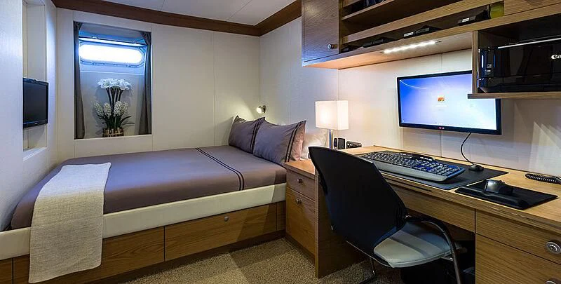 a bedroom with a bed desk and a computer aboard GARCON Yacht for Sale