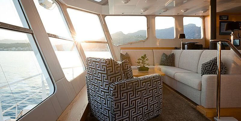 a living room with a couch and a window aboard GARCON Yacht for Sale