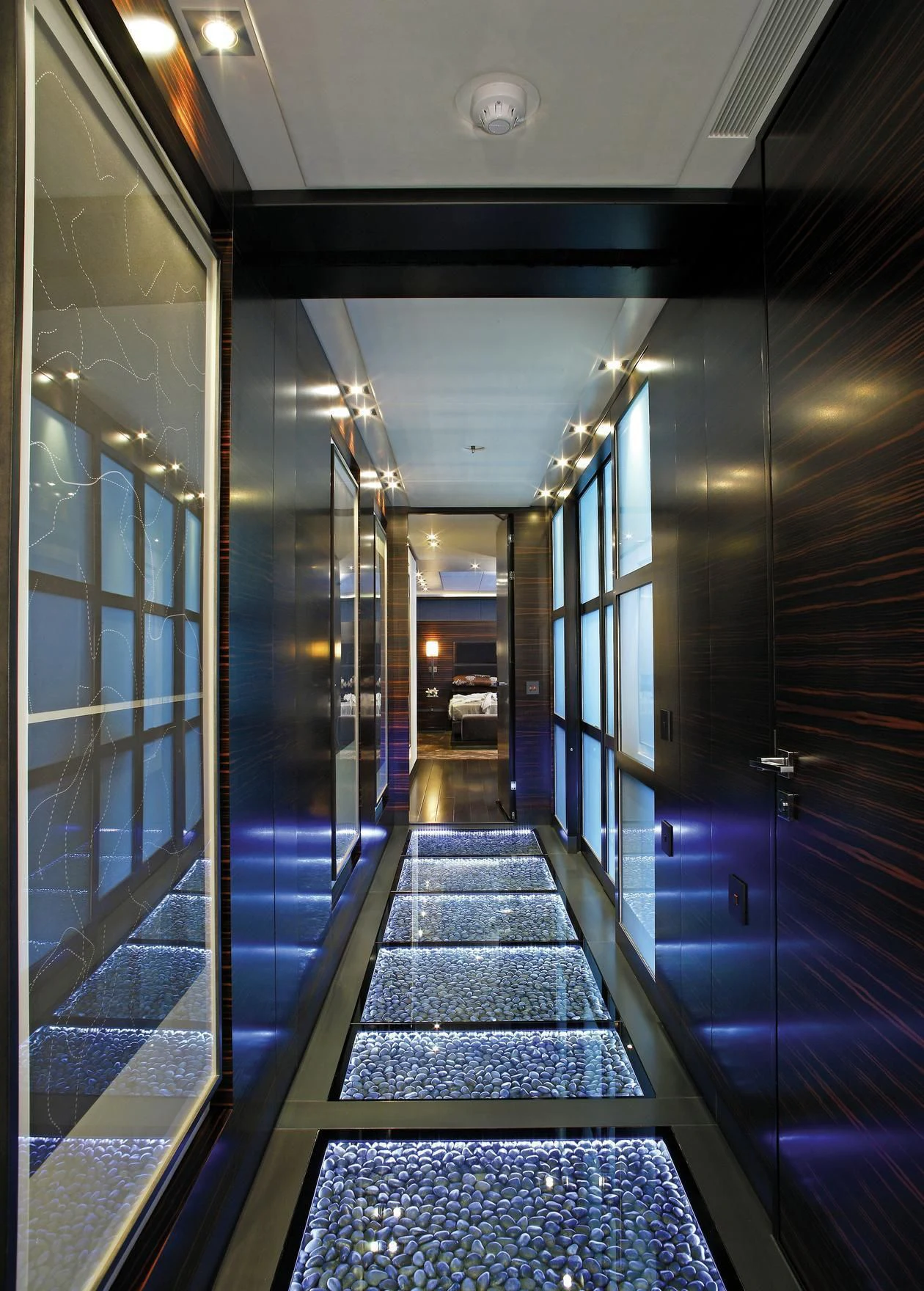 a long hallway with blue lighting aboard R JUNIORS Yacht for Sale
