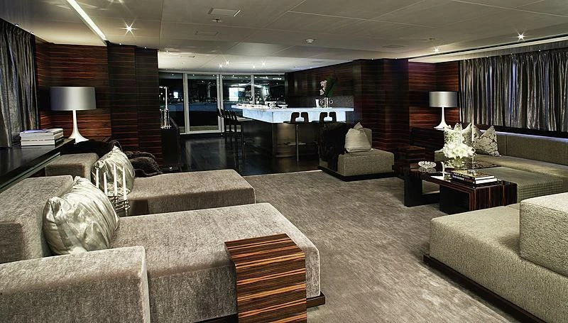 a large living room with a large table and couches aboard R JUNIORS Yacht for Sale