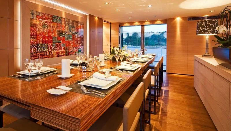 a large dining table with a large window aboard FAN TOO Yacht for Sale