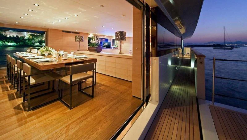 a room with a table and chairs aboard FAN TOO Yacht for Sale