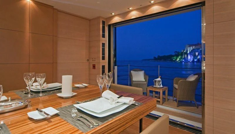 a table with plates and glasses on it aboard FAN TOO Yacht for Sale