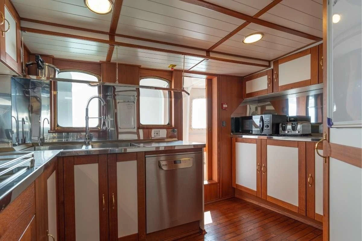 a kitchen with wooden cabinets aboard CAMARA C Yacht for Sale