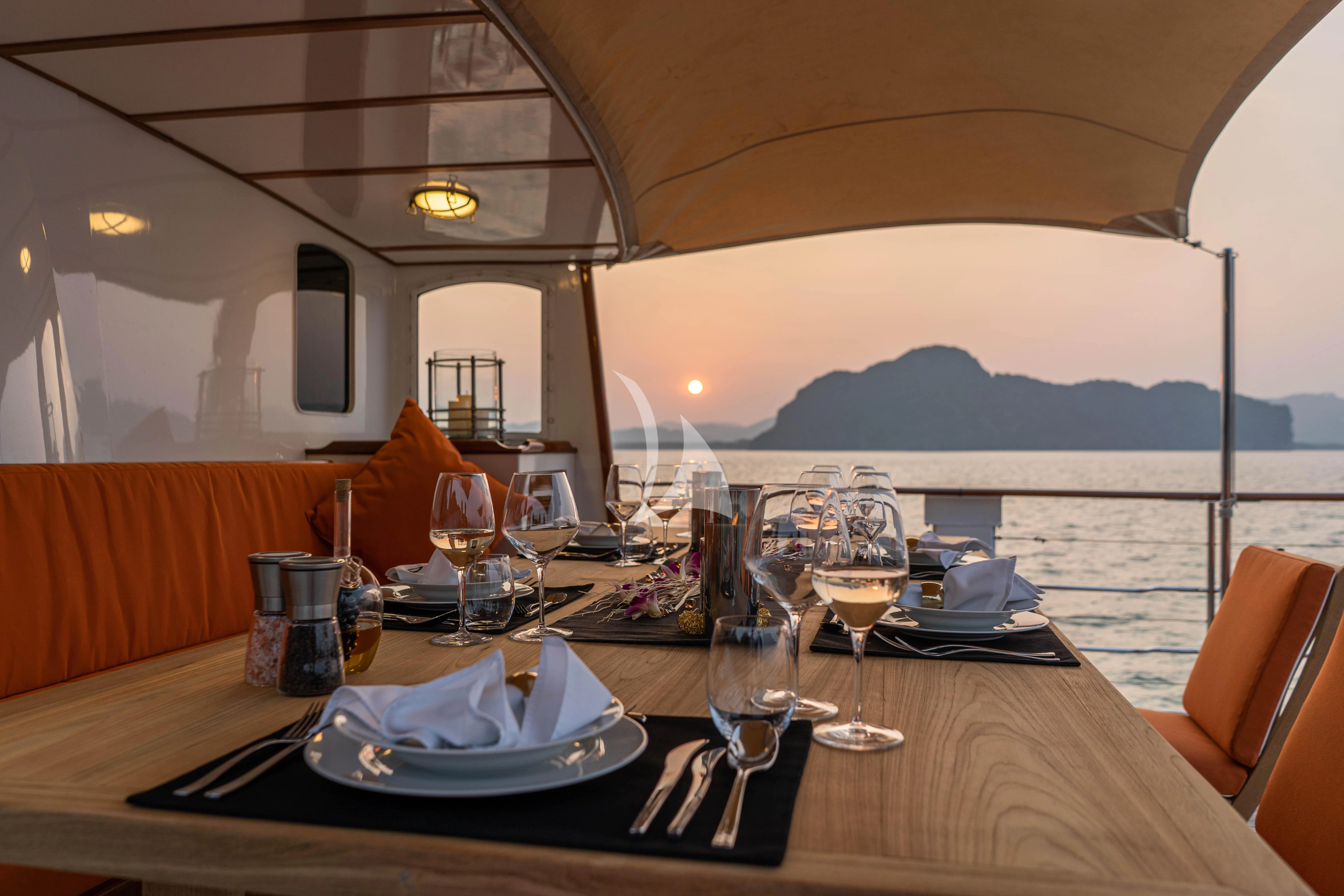 a table with plates and glasses on it aboard CAMARA C Yacht for Sale