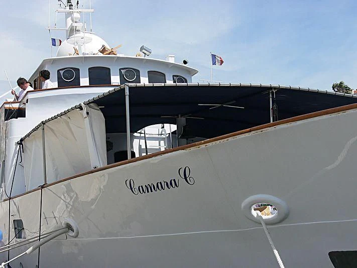 a large white boat with a flag on the deck aboard CAMARA C Yacht for Sale