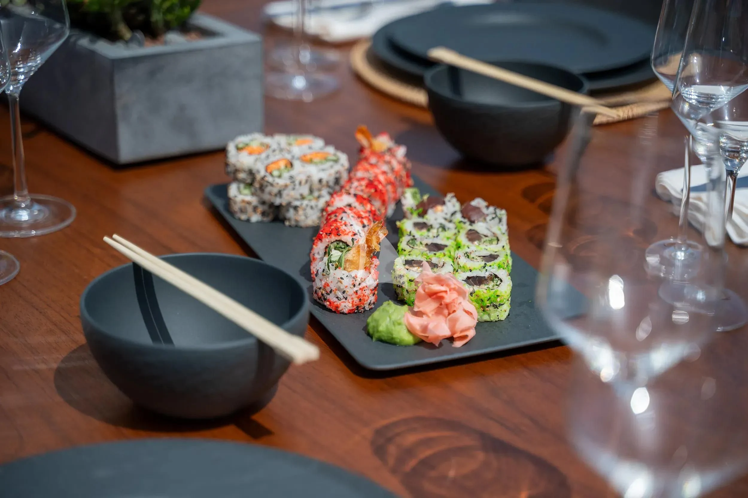 a plate of sushi and chopsticks on a table aboard PAREAKI II Yacht for Sale