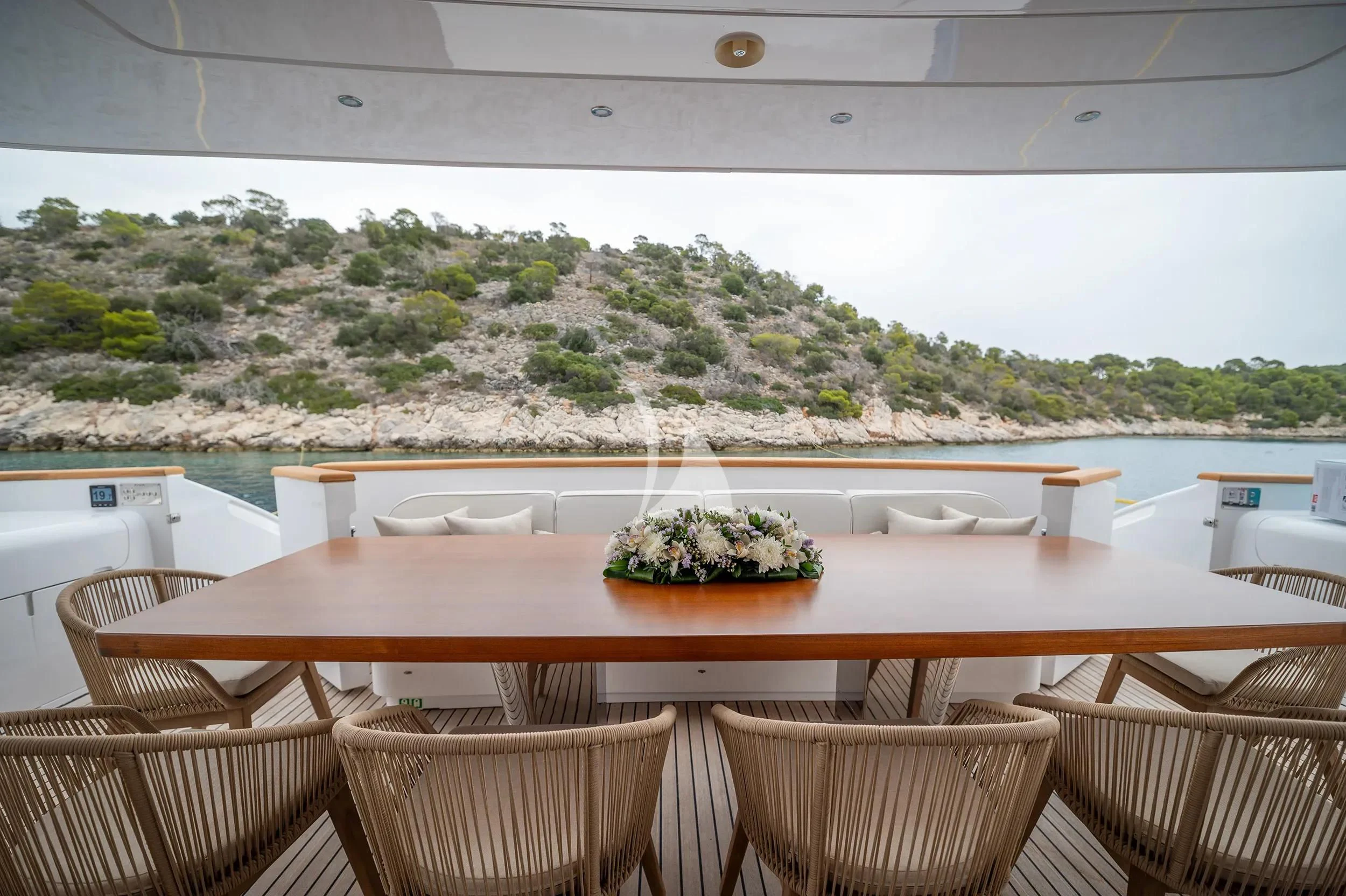a table with chairs and plants on it aboard PAREAKI II Yacht for Sale