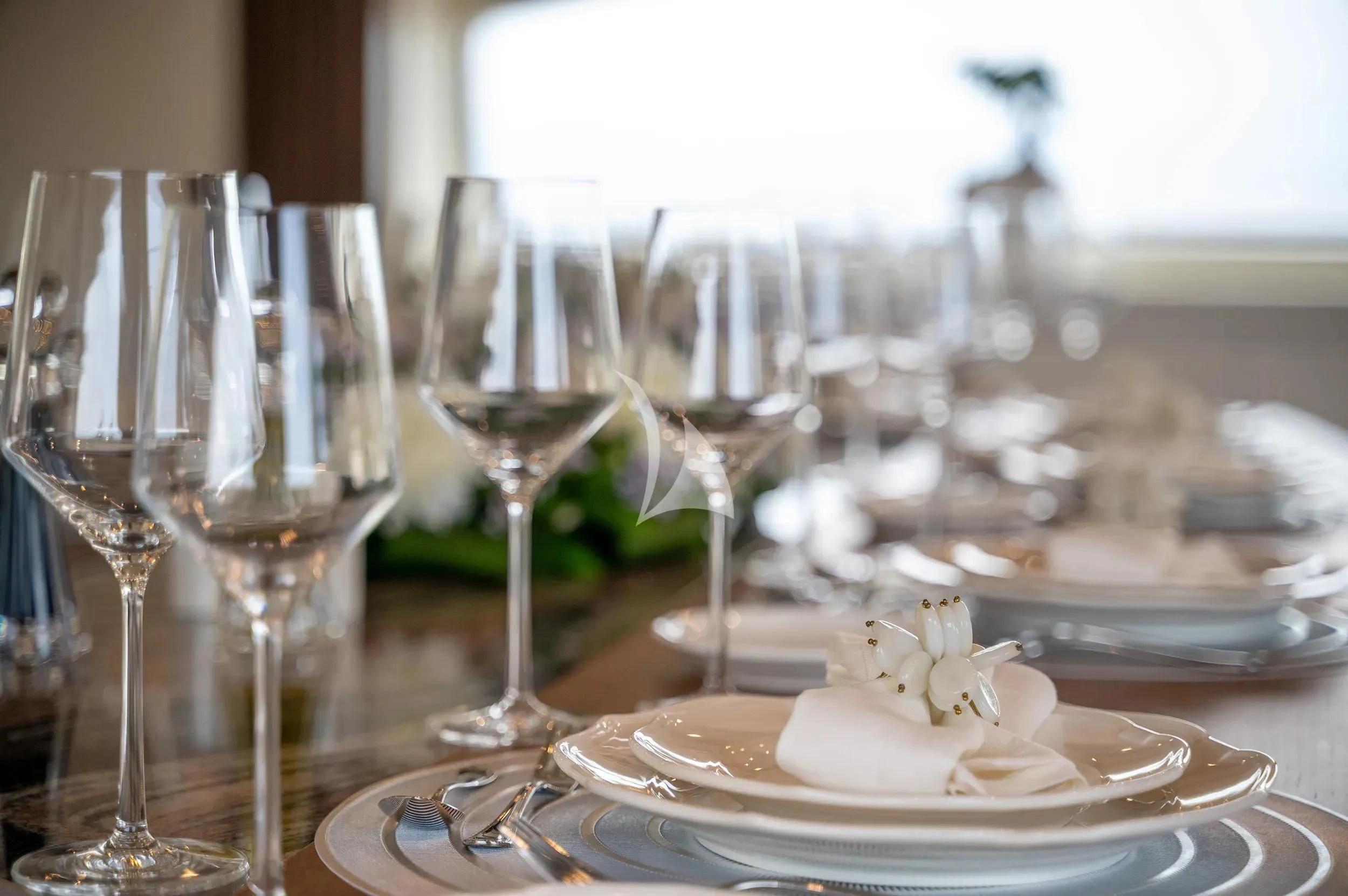 a table with plates and glasses of wine aboard PAREAKI II Yacht for Sale