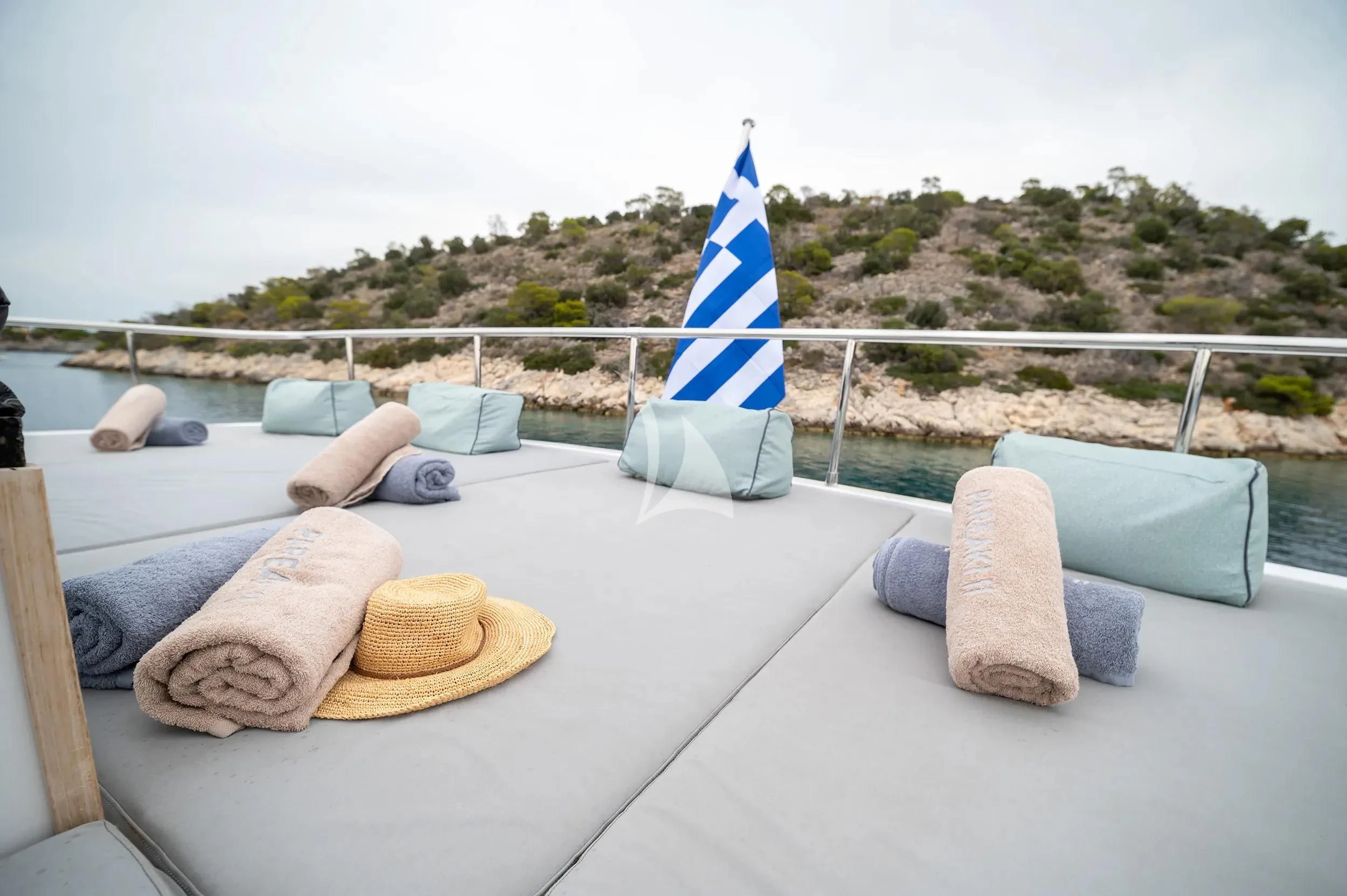 a blue and white striped boat on a deck with a blue sail aboard PAREAKI II Yacht for Sale