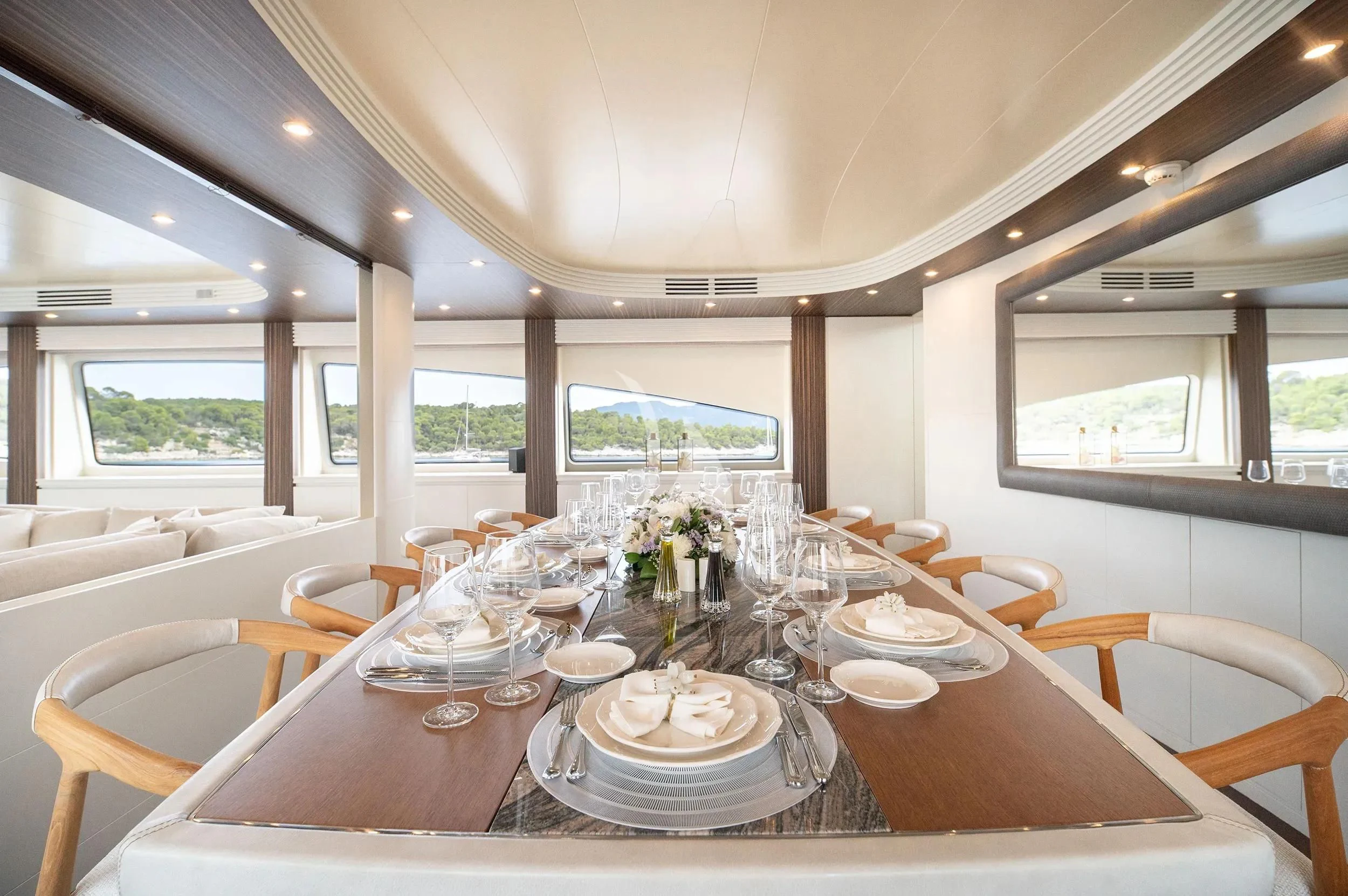 a dining table with plates and glasses aboard PAREAKI II Yacht for Sale