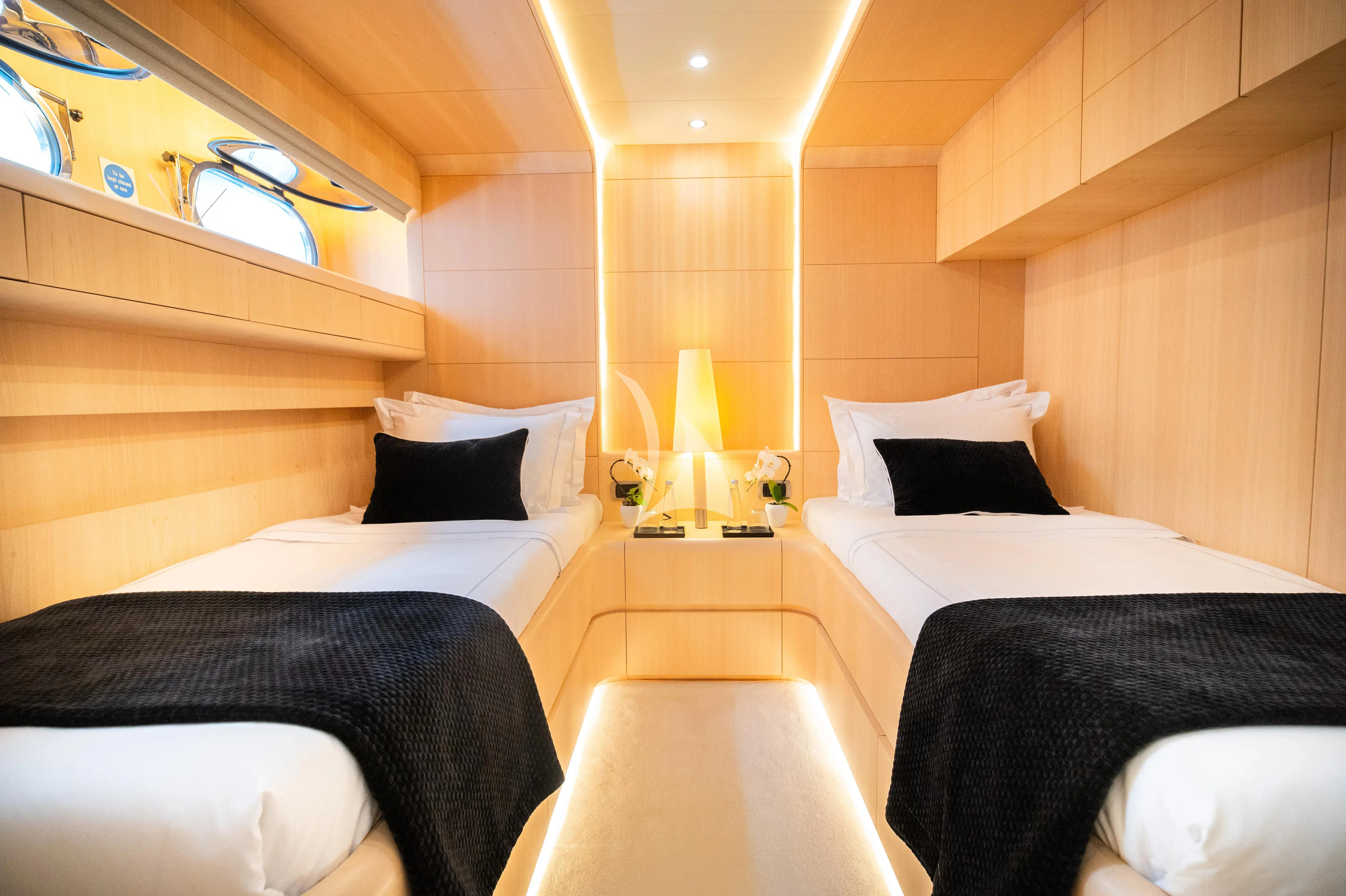 a room with beds and a table aboard PAREAKI II Yacht for Sale