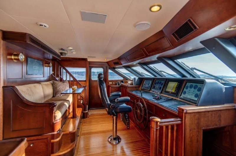 a living room with a wood table and chairs aboard HER IDEA Yacht for Sale