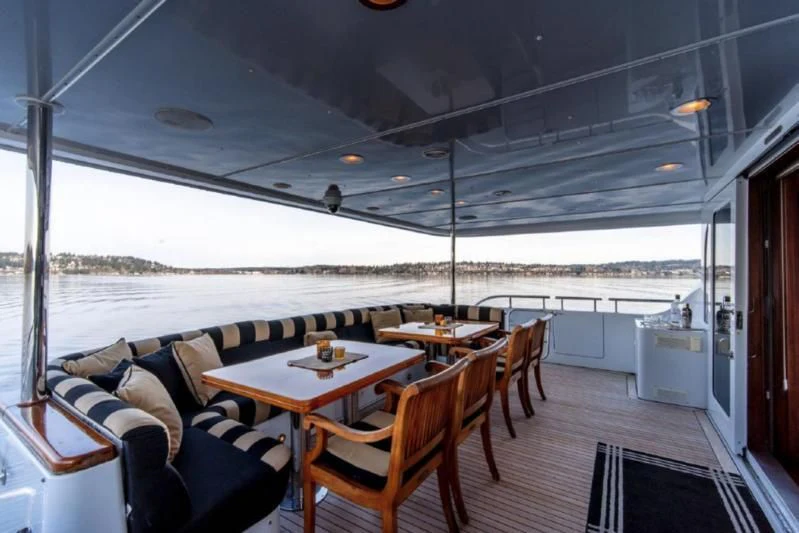 a large boat with a table and chairs and a couch aboard HER IDEA Yacht for Sale