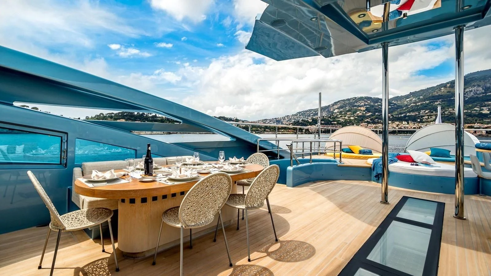 a table and chairs on a deck overlooking a body of water aboard QUEEN ALLA Yacht for Sale