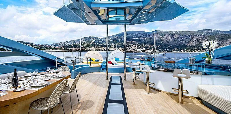 a deck with a table chairs and a view of a city aboard QUEEN ALLA Yacht for Sale