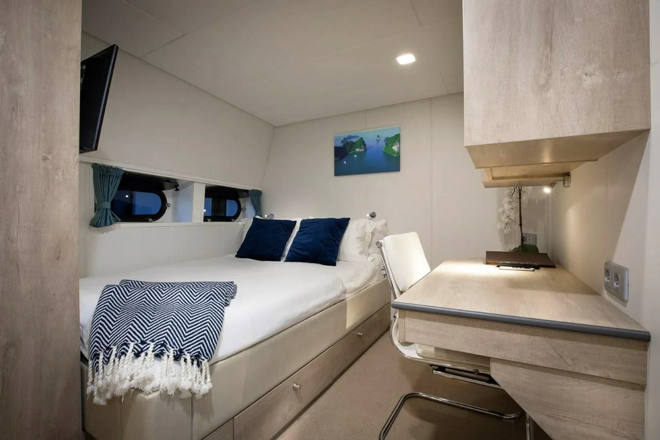 a room with a bed and desk aboard CHASING ROMANCE Yacht for Sale