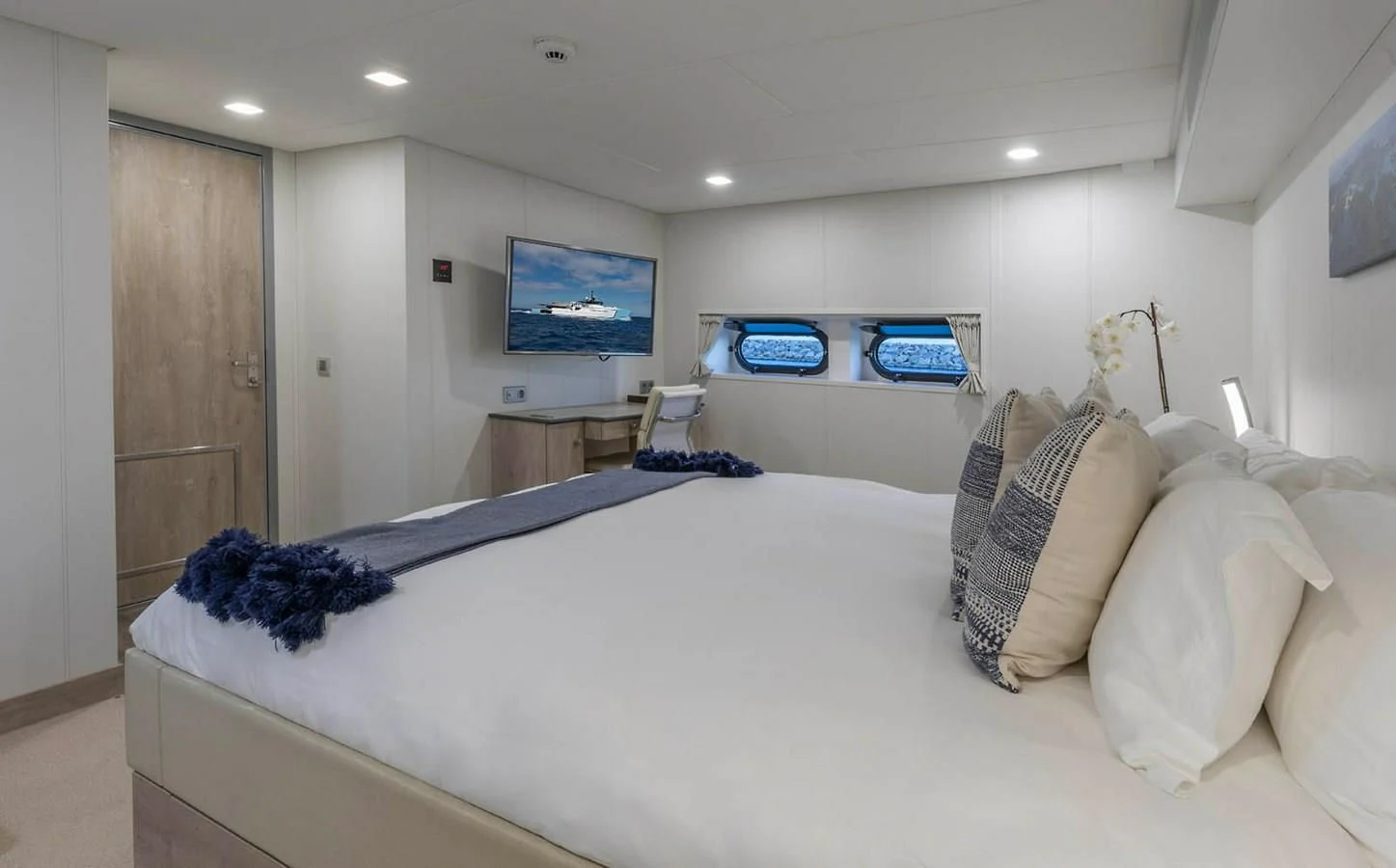 a bedroom with a bed and a tv on the wall aboard CHASING ROMANCE Yacht for Sale