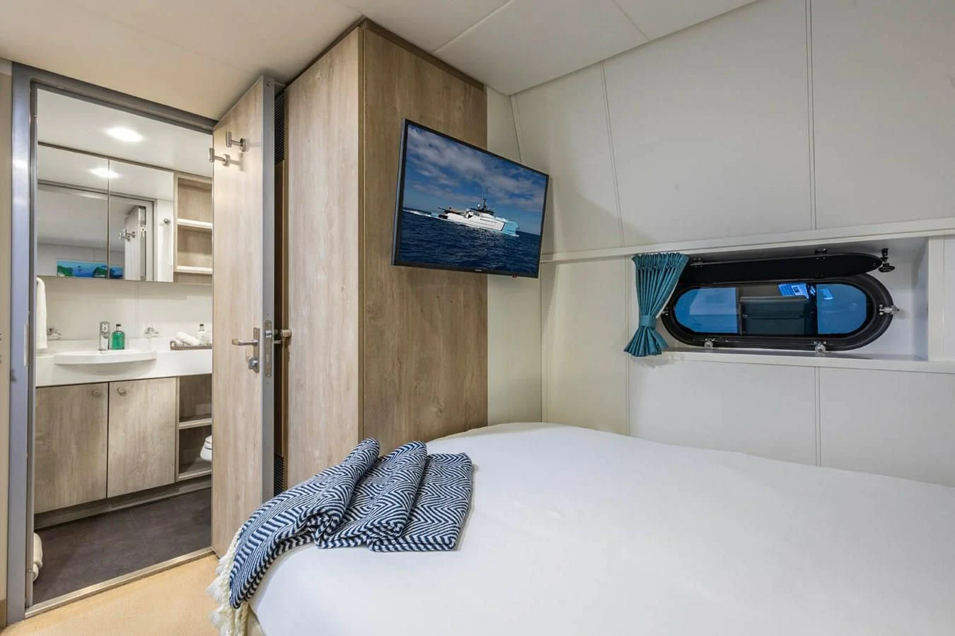 a bedroom with a television on the wall aboard CHASING ROMANCE Yacht for Sale