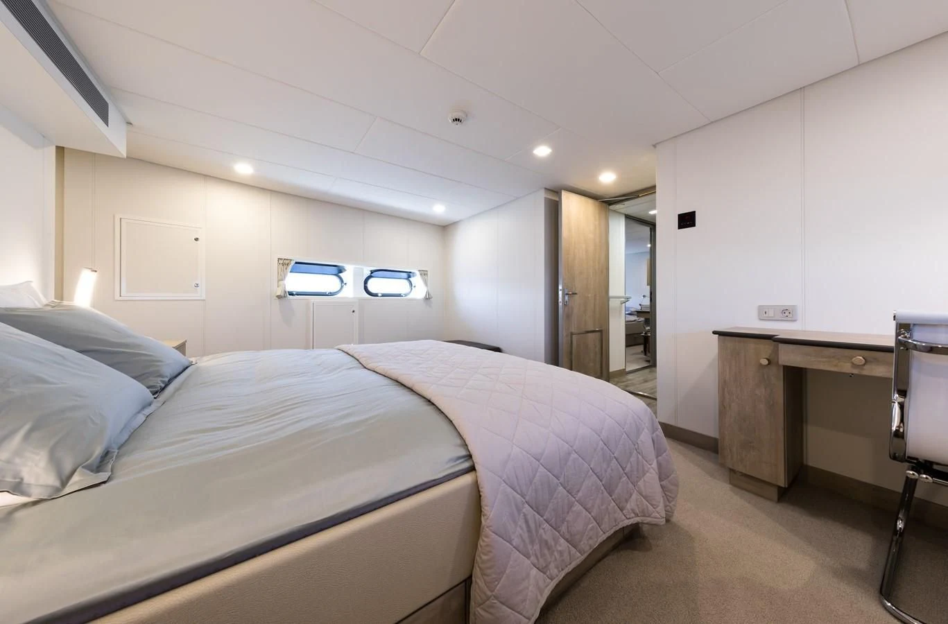 a bedroom with a bed and desk aboard CHASING ROMANCE Yacht for Sale