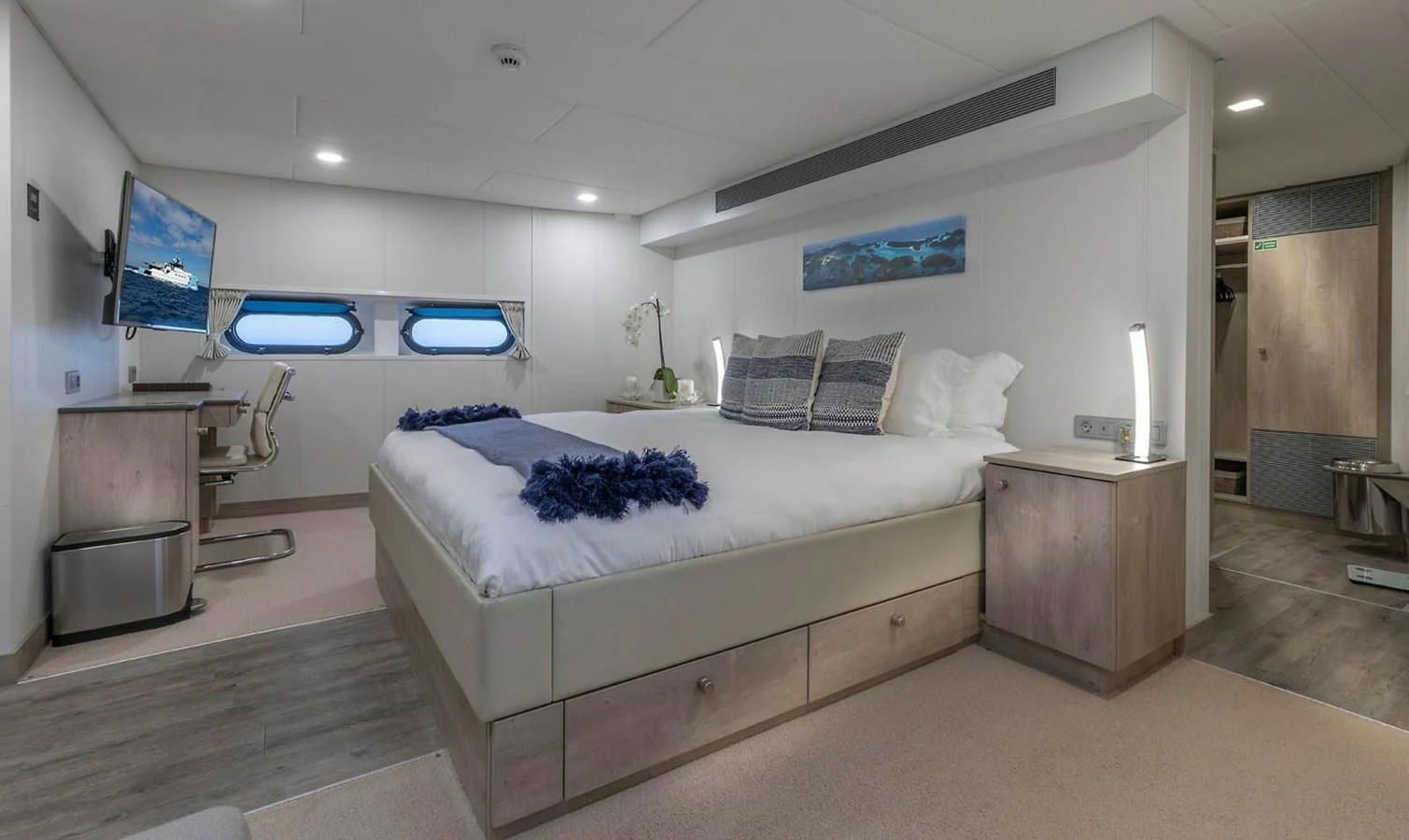 a bedroom with a bed and a tv on the wall aboard CHASING ROMANCE Yacht for Sale