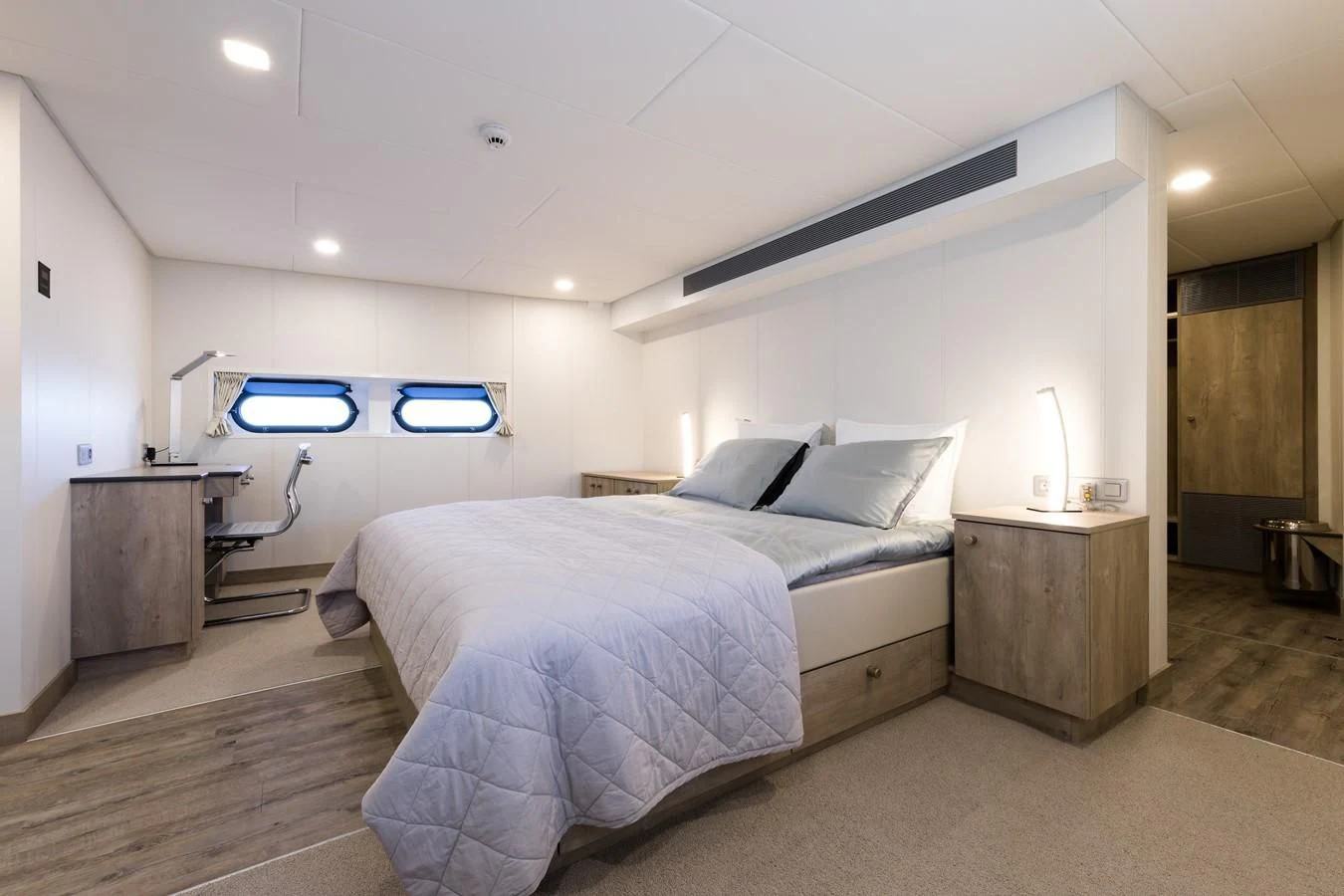 a bedroom with a bed and a desk aboard CHASING ROMANCE Yacht for Sale