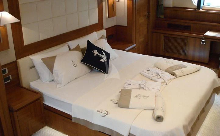 a bed with white sheets and pillows aboard COSMOS LUNA Yacht for Sale
