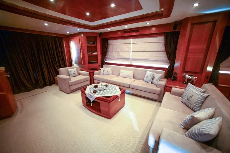 a living room with a red couch and a red table aboard COSMOS LUNA Yacht for Sale
