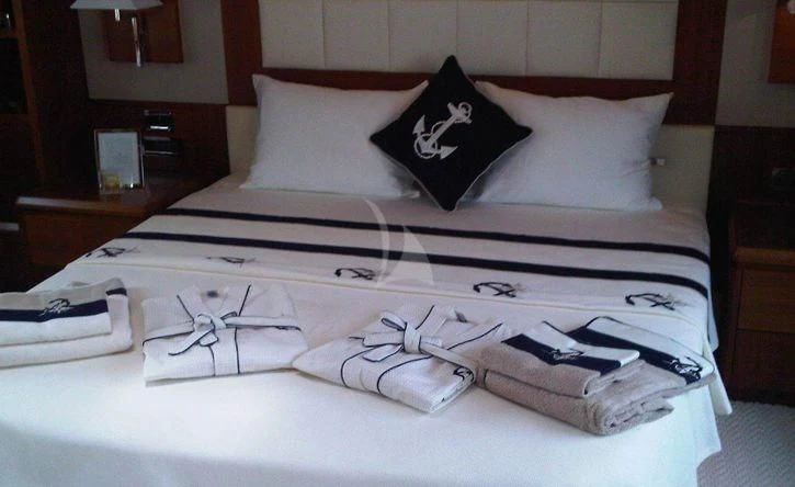 a bed with white sheets and pillows aboard COSMOS LUNA Yacht for Sale