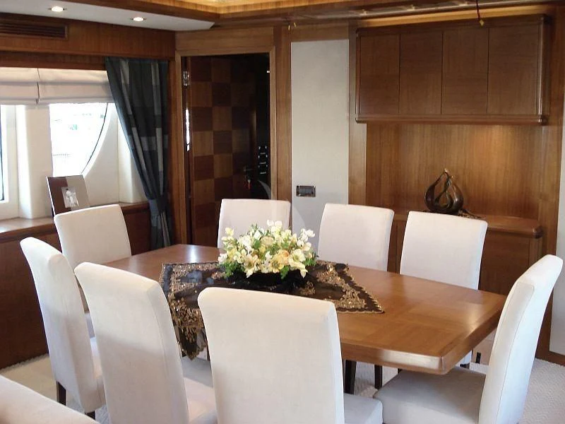 a table with chairs and a vase of flowers on it aboard COSMOS LUNA Yacht for Sale