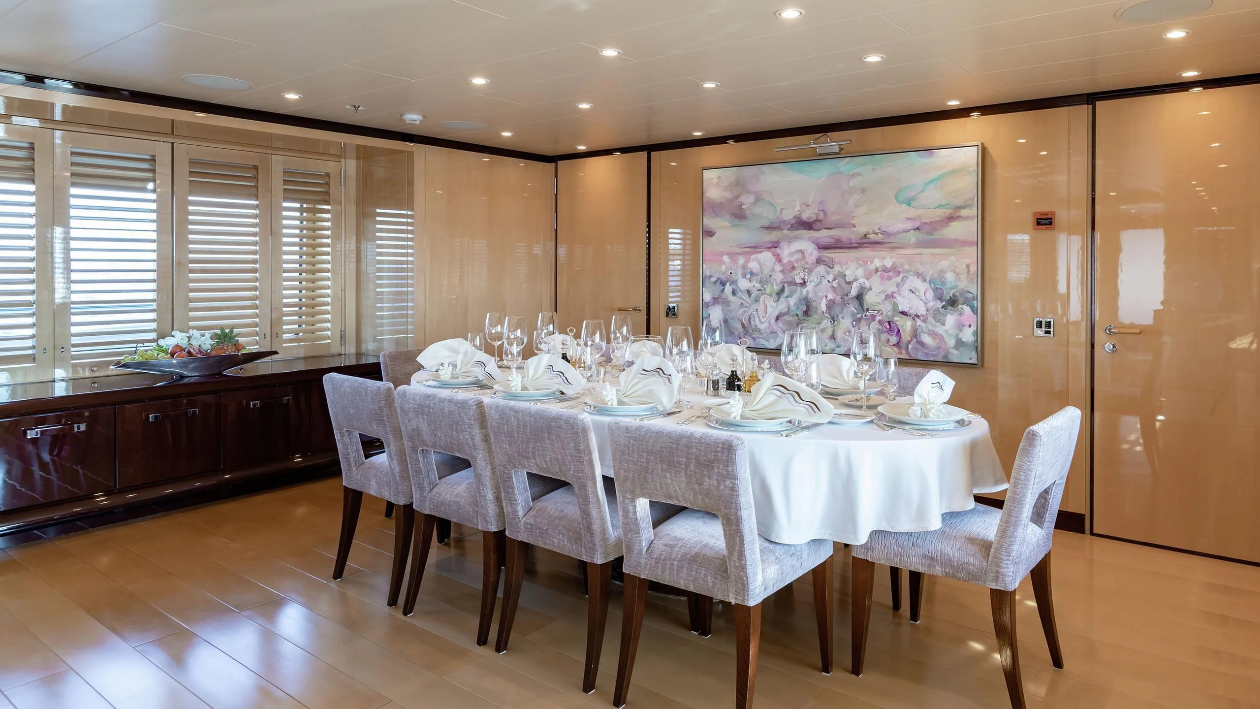 a large dining table in a large room with a large painting aboard LA MIRAGE Yacht for Sale